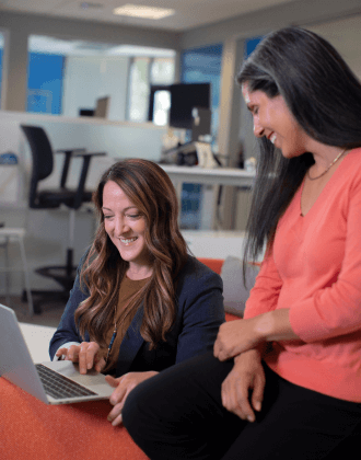 Team members reviewing work on a laptop